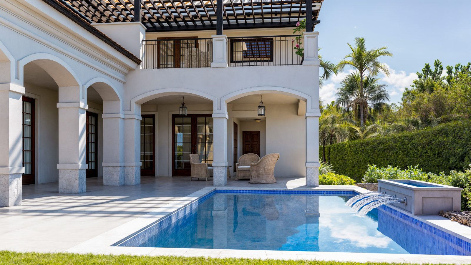 Rear loggia with arched openings, opening to the pool and its raised spa.