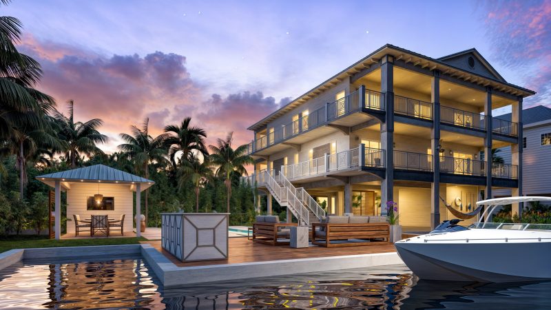 Three-story stilted coastal residence at dusk, with a dock, cabana and boat lift on the canal.