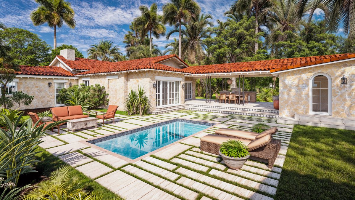 Courtyard pool of a Mediterranean residence with barrel-tile roofs, coral stone walls and travertine pavers.